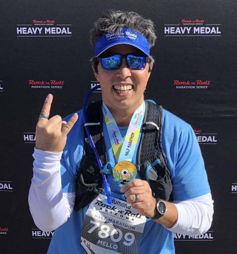 Carmelo showing off his medal from running a half marathon in 2020